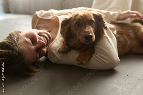 pretty woman lying on a floor with her dog photo