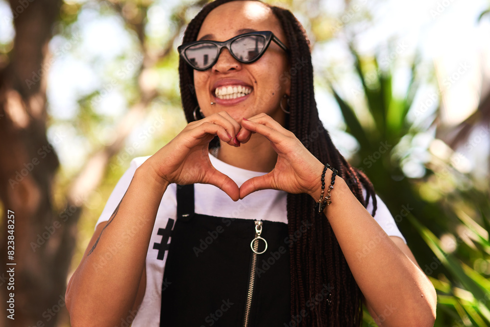 African woman, student and outdoor with heart hands, summer and sunglasses in park with love in sunshine. Girl, person and smile with symbol, kindness and icon with choice on vacation in urban garden African woman, student and outdoor with heart hands, summer and sunglasses in park with love in sunshine. Girl, person and smile with symbol, kindness and icon with choice on vacation in urban garden