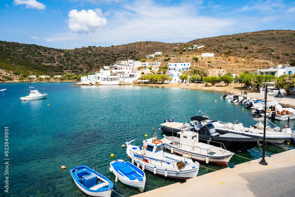 Typical Greek fishing boats anchoring in Faros port and mountains in background, Sifnos island, Greece