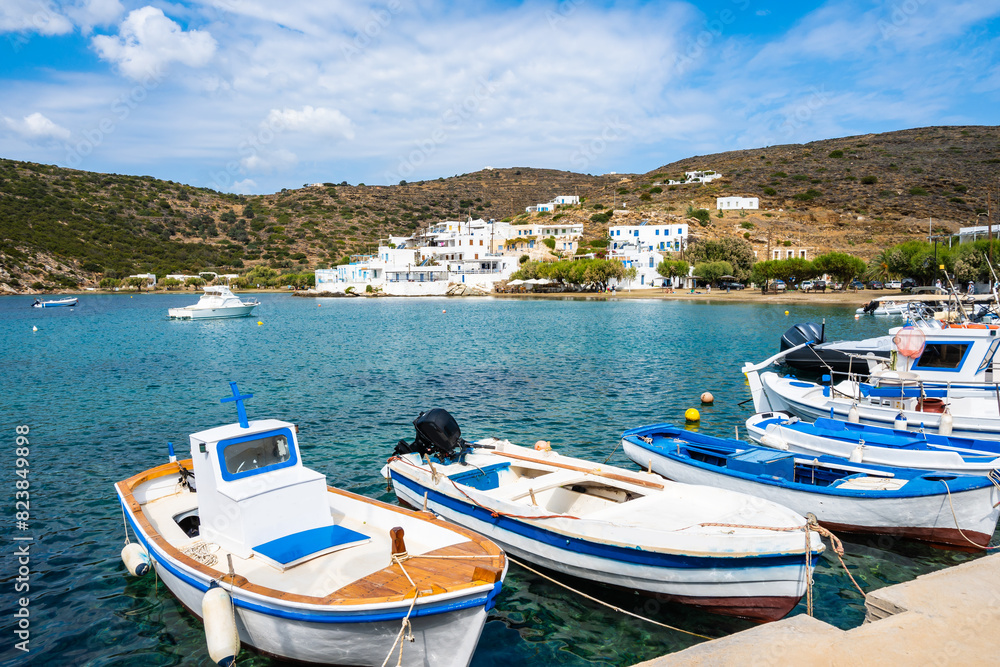 Typical Greek fishing boats anchoring in Faros port and mountains in background, Sifnos island, Greece