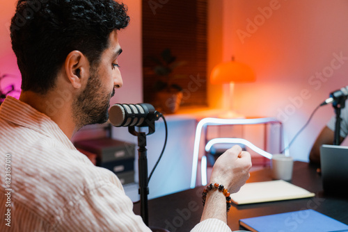 A man speaks into a microphone in the studio photo