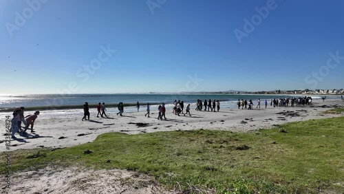 Melkbosstrand west coast South Africa.  19.04.2024.  Group of school children walking along the  beach during a visit to the seaside resort of Melkbosstrand on the west coast of South Africa. photo