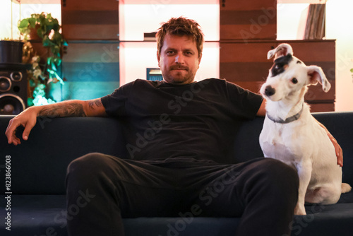 Portrait of a artist relaxing with his pet in apartment couch photo