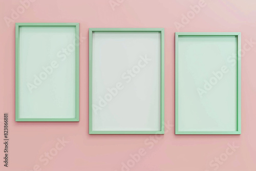 a mock-up of three empty posters in green frames on a pastel pink background.