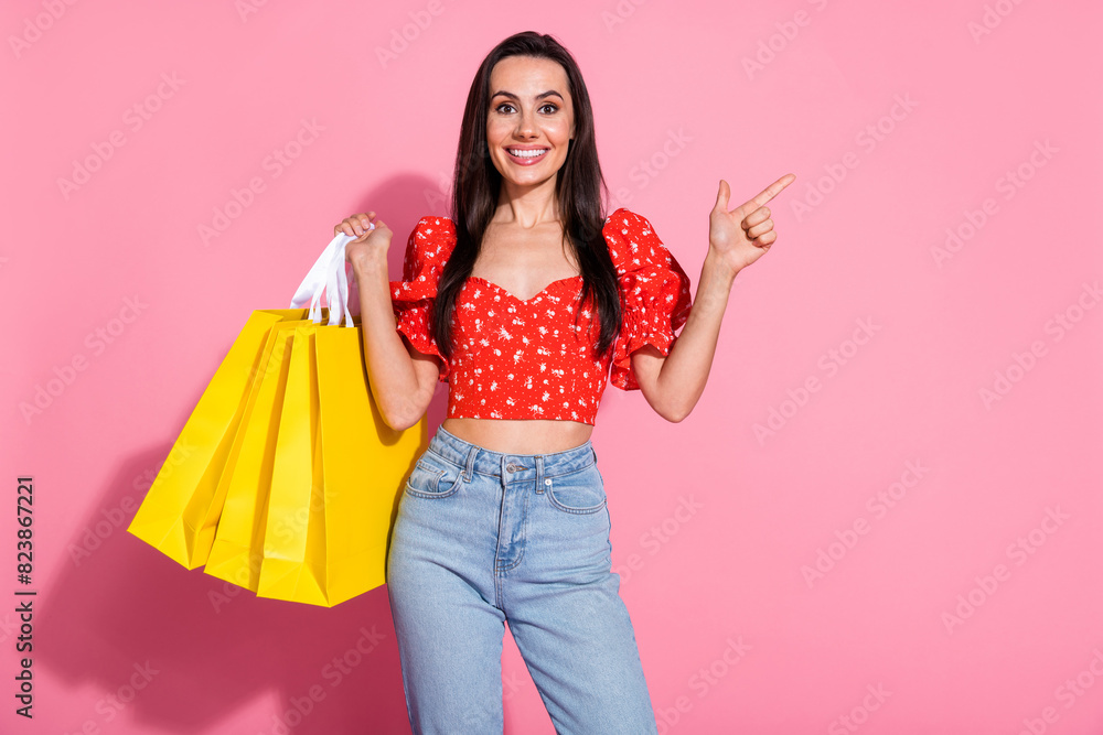 Portrait of nice young lady direct finger empty space wear top isolated on pink color background Portrait of nice young lady direct finger empty space wear top isolated on pink color background