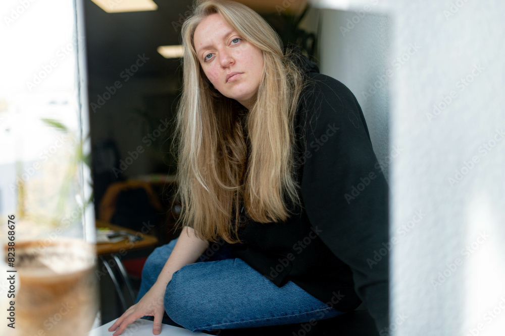 a woman in a black sweater and blue jeans a woman in a black sweater and blue jeans