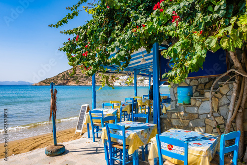 Fotografía Blue chairs and tables in traditional Greek taverna restaurant on sandy beach in