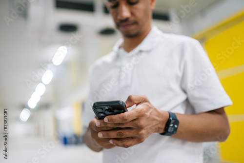 Male employee using smartphone while setting cameras in building photo