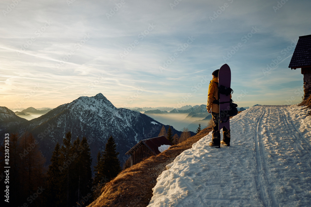 Snowboarder standing on a snowy path Snowboarder standing on a snowy path