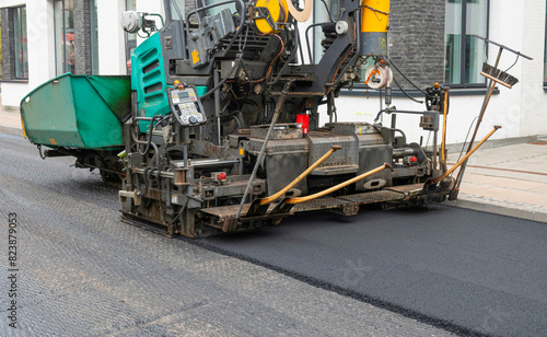 Repair of asphalt road surface - old layer removed and a coating Industrial pavement truck laying new fresh asphalt on construction site. Copenhagen, Denmark - May 4, 2024. © Ole