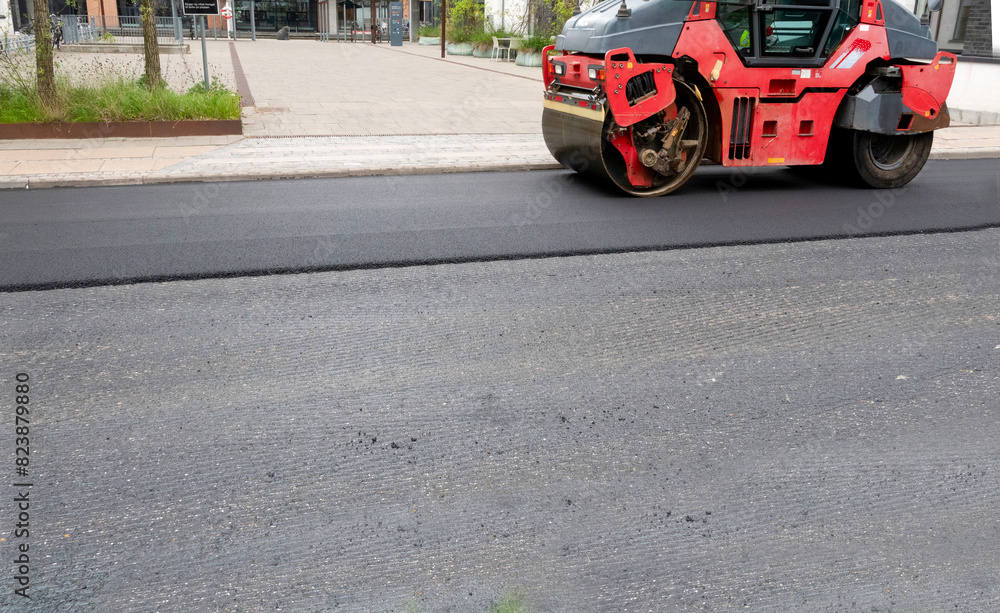 Obraz premium Road construction asphalt roller machine at work. Heavy Vibration roller compactor at pavement works for road repairing. Scraped and new asphalt for road resurfacing.