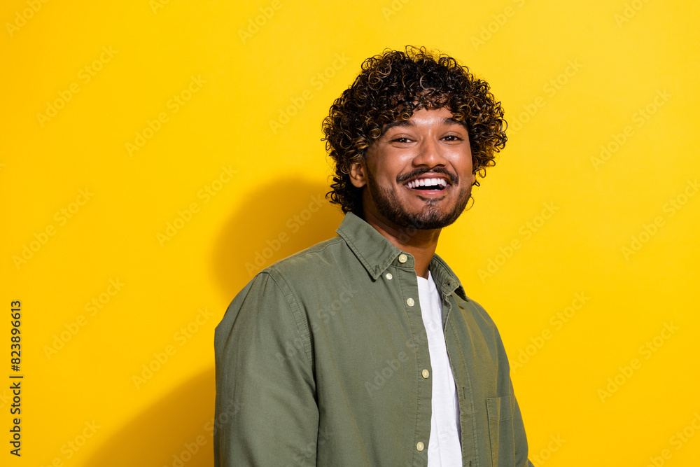 Portrait photo of young hispanic optimistic handsome businessman migrant in khaki shirt isolated on yellow color background Portrait photo of young hispanic optimistic handsome businessman migrant in khaki shirt isolated on yellow color background