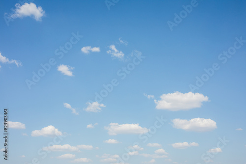 Light blue sky with small white clouds photo