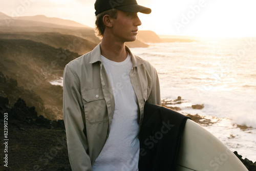 Surfer gazing toward the ocean, getting ready to surf photo