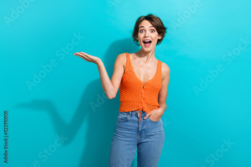 Photo of overjoyed woman dressed knitwear singlet arm presenting impressive sale empty space isolated on turquoise color background photo
