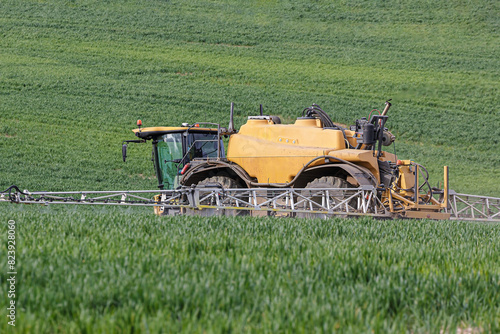 Farmer using a self propelled crop sprayer in a field in early spring.