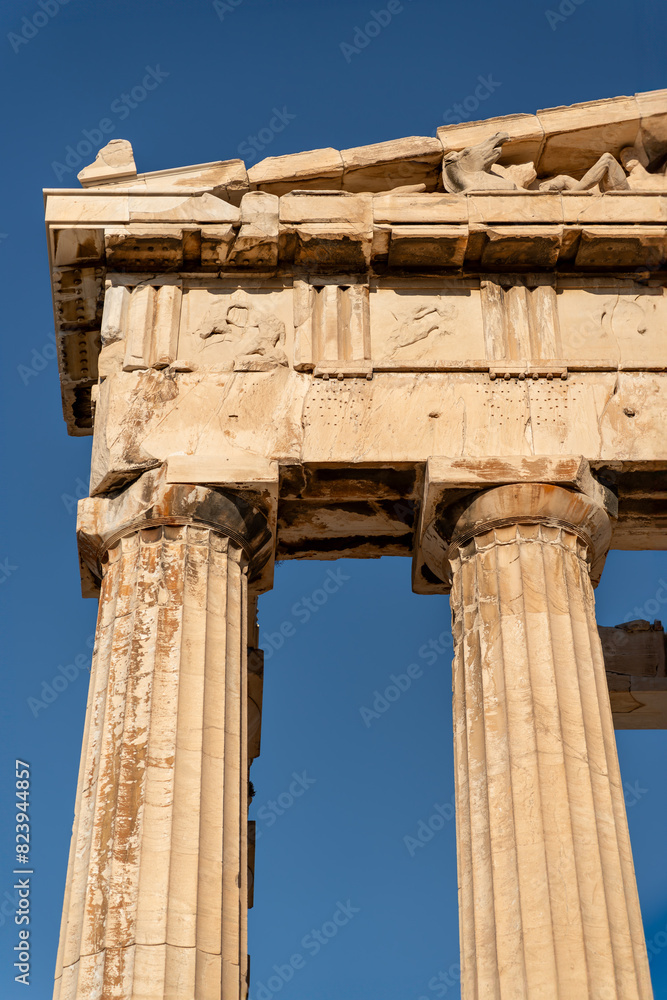 Upper part of an ancient Greek temple, The Parthenon. It features Doric columns and a pediment adorned with sculptural details