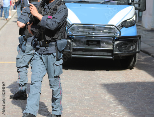 Riot police officer in riot gear with bulletproof vest during a protest demonstration in the city and an police van