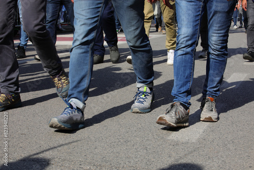 shoes and legs of men walking in the city during the peaceful protest demonstration photo