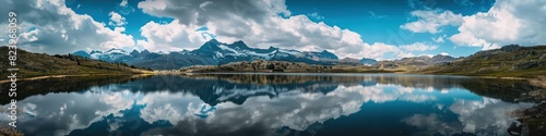 mountain range with a lake reflecting the blue sky with dramatic clouds © XTSTUDIO