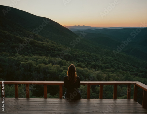 Woman Enjoying Mountain Sunset from Wooden Deck