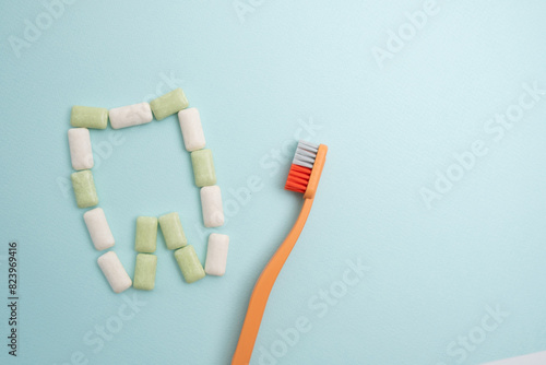 Toothbrush and chewing gum lie on a colored background. Time to brush your teeth. Top view, flat lay. Dental health concept © Iuliia Pilipeichenko