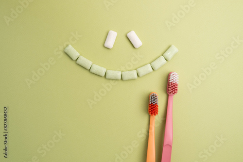 Toothbrush and chewing gum lie on a colored background. Time to brush your teeth. Top view, flat lay. Dental health concept © Iuliia Pilipeichenko