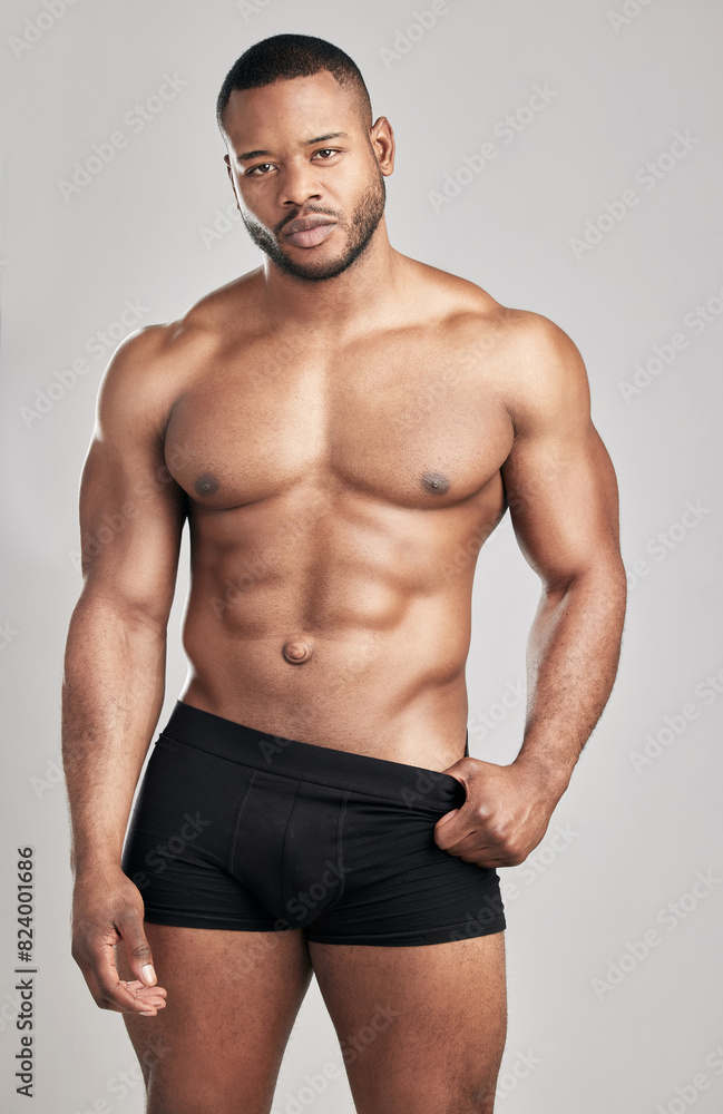 Portrait, muscle and black man in studio in underwear with abdomen for fitness, exercise and body health in Kenya. Confidence, shirtless and strong bodybuilder with abs isolated on white background Portrait, muscle and black man in studio in underwear with abdomen for fitness, exercise and body health in Kenya. Confidence, shirtless and strong bodybuilder with abs isolated on white background