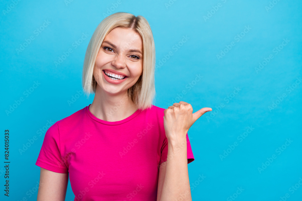 Photo portrait of lovely young lady point empty space dressed stylish pink clothes isolated on blue color background Photo portrait of lovely young lady point empty space dressed stylish pink clothes isolated on blue color background