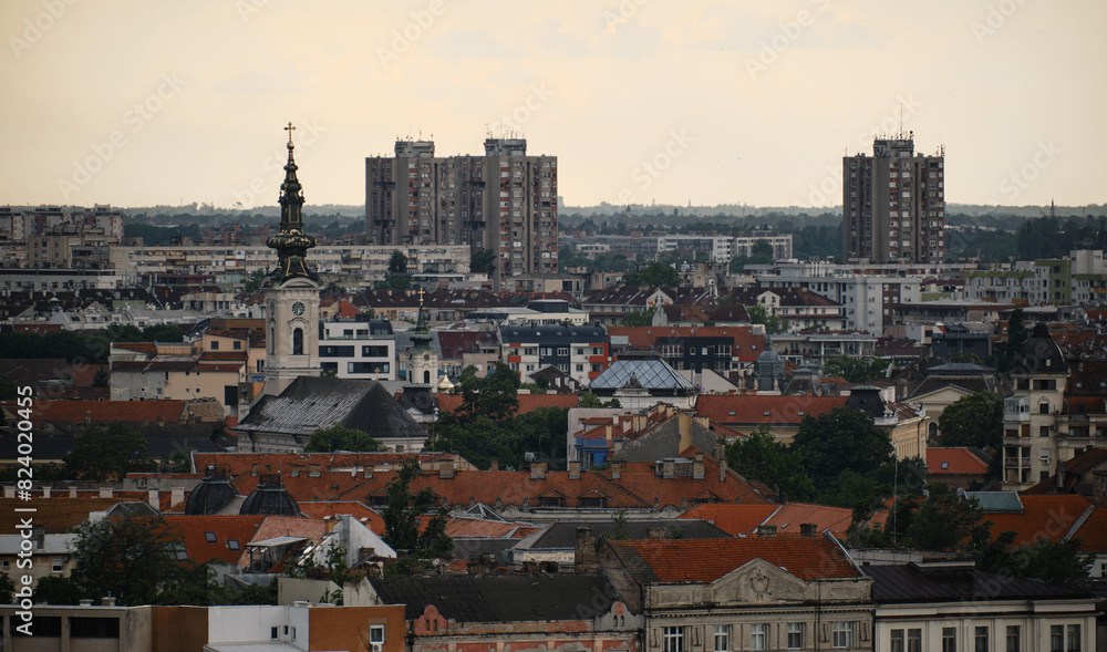 Serbia - Beautiful Panoramic view of Novi Sad and Danube River, spring cloudy evening. Red tiled roofs of houses and church towers with clocks. View from Petrovaradin fortress. Serbia - Beautiful Panoramic view of Novi Sad and Danube River, spring cloudy evening. Red tiled roofs of houses and church towers with clocks. View from Petrovaradin fortress.