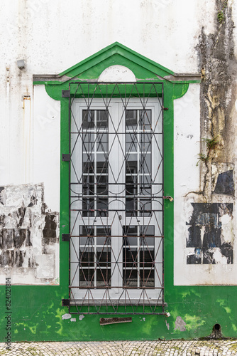 Green trimmed window on a white building.