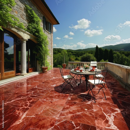 An outdoor terrace floored with Rosso Lepanto marble, the rich red stone setting a dramatic stage for al fresco dining under the stars. photo