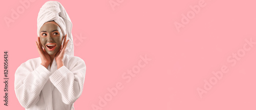 Happy young woman with applied clay mask on pink background