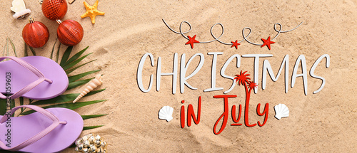 Banner with text CHRISTMAS IN JULY, beach accessories and decorations on sand