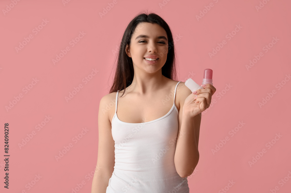 Happy smiling young woman with crystal deodorants on pink background Happy smiling young woman with crystal deodorants on pink background