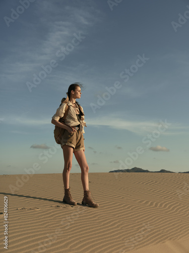 Lonely woman standing in the vast desert landscape, gazing into the unknown horizon photo