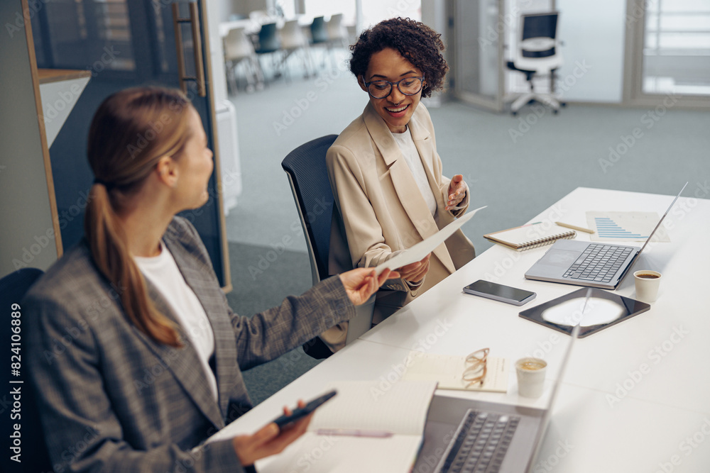 Two female professional executives experts discussing financial accounting papers working together Two female professional executives experts discussing financial accounting papers working together