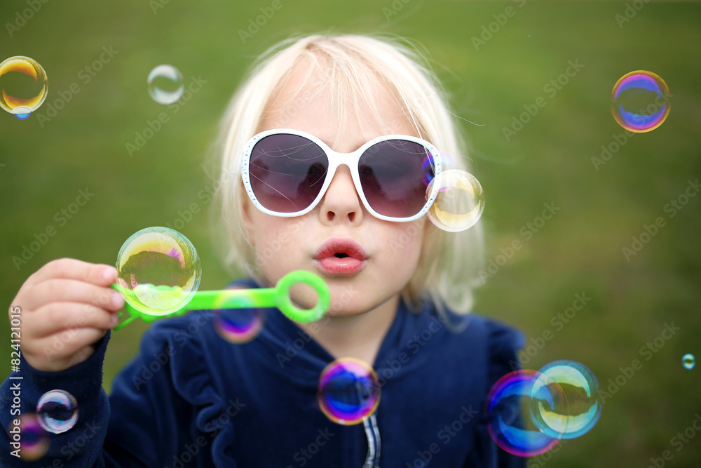 Cute Little Girl Child Blowing Bubbles Outside on a Summer Day