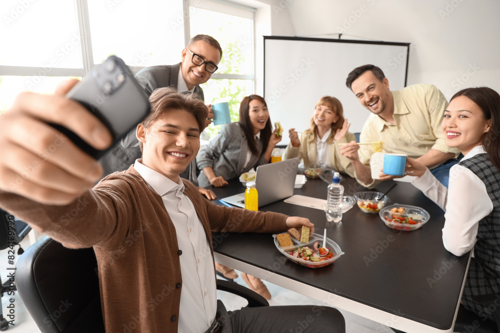 © Pixel-Shot - Group of business people taking selfie during lunch in office
