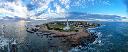 Costa con faro al atardecer en el mar La paloma, uruguay 
