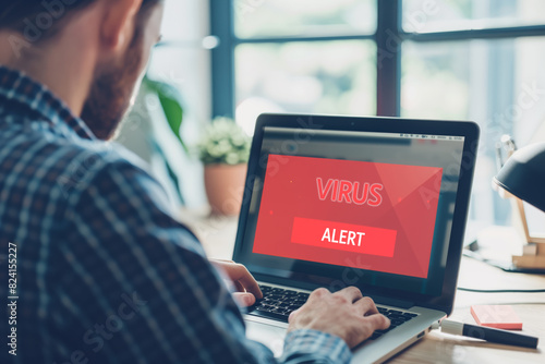 Man receiving virus alert on laptop screen