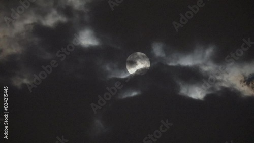 NORMAL SPEED VIDEO OF DRAMATIC NIGHT SKY WITH FULL MOON AMONG THE DARK CLOUDS