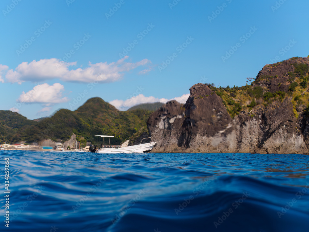 ヒリゾ浜渡船の漁船の美しい半水面撮影。 日本国静岡県伊豆半島賀茂郡南伊豆町中木から渡し船で渡るヒリゾ浜にて。 2022年夏水中撮影。 A beautiful half-water shot of a fishing boat on the Hirizohama beach ferry. Hirizohama beach, by ferry from Nakagi, Minami-Izu-ch