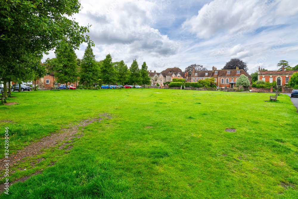 Historic brick townhomes line the Choristers Square Park, in the Cathedral Close district alongside the medieval cathedral, in Salisbury, England, UK. Historic brick townhomes line the Choristers Square Park, in the Cathedral Close district alongside the medieval cathedral, in Salisbury, England, UK.