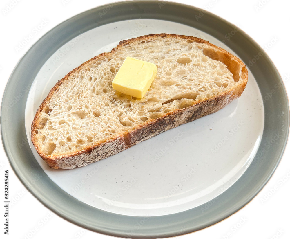 A piece of sliced sourdough bread on top with butter served on the plate with white background. A piece of sliced sourdough bread on top with butter served on the plate with white background.