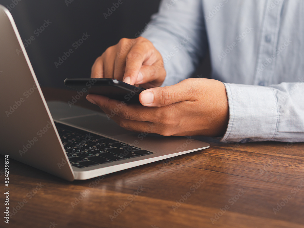 Businessman using a smartphone while sitting at a desk in the office. Businessman using a smartphone while sitting at a desk in the office.