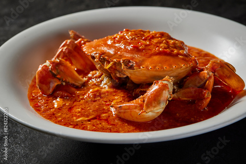 traditional chinese wok fried seafood fresh big meat crab with chilli spicy salted egg yolk cheese cream sauce in plate on dark stone table asian cafe hotel luxury halal food restaurant banquet menu
