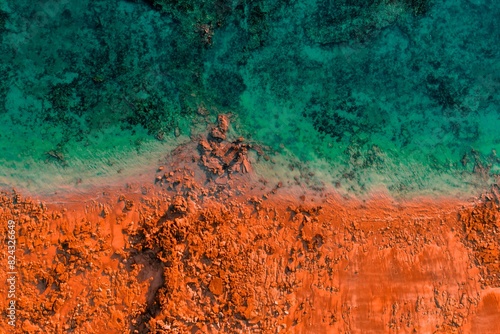 Aerial View of Orange Red Rocky Beach and Turquoise Water