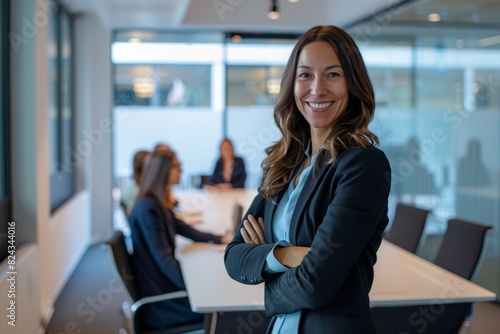 Young successful businesswoman at corporate office looking at camera. Office business portrait