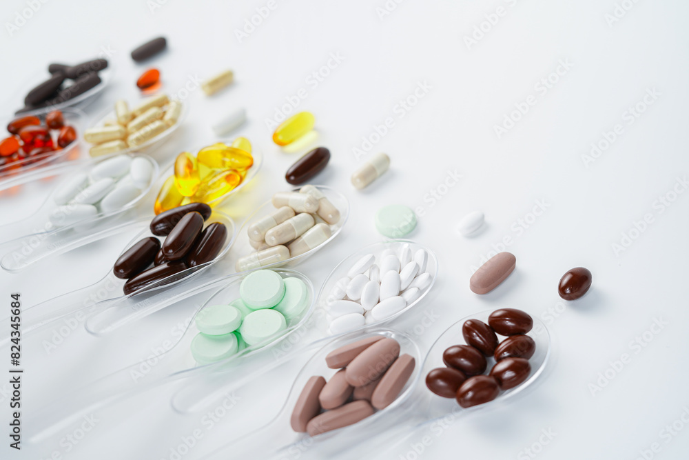 Various vitamin and mineral pills, food supplement health product in transparent spoon Various vitamin and mineral pills, food supplement health product in transparent spoon
